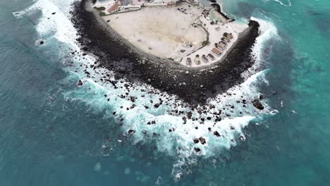 aerial view of a rocky island with breaking waves
