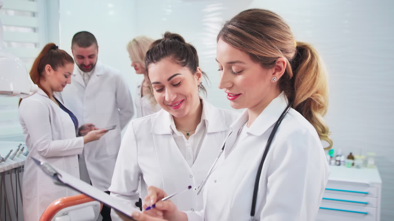 Doctors in the dental office. Talking nurses and one noting doctor