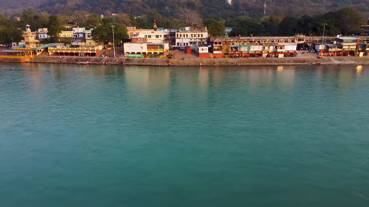 la orilla del río sagrado ganges llena de templos religiosos al atardecer se toma un video aéreo en rishikesh uttrakhand india el 15 de marzo de 2022