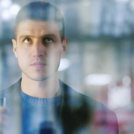 a man with a credit card in his hand stands at window of a boutique 1