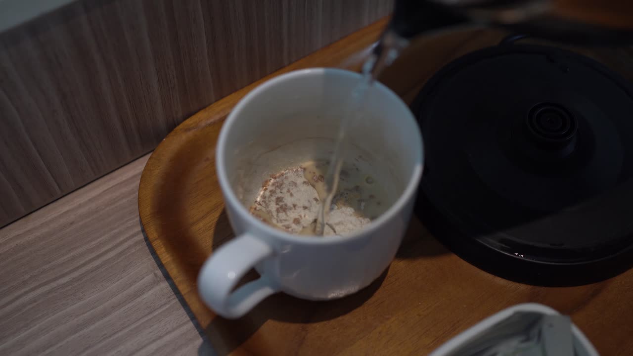 시리얼 음료가 담긴 흰색 컵에 끓인 물을 붓는 과정