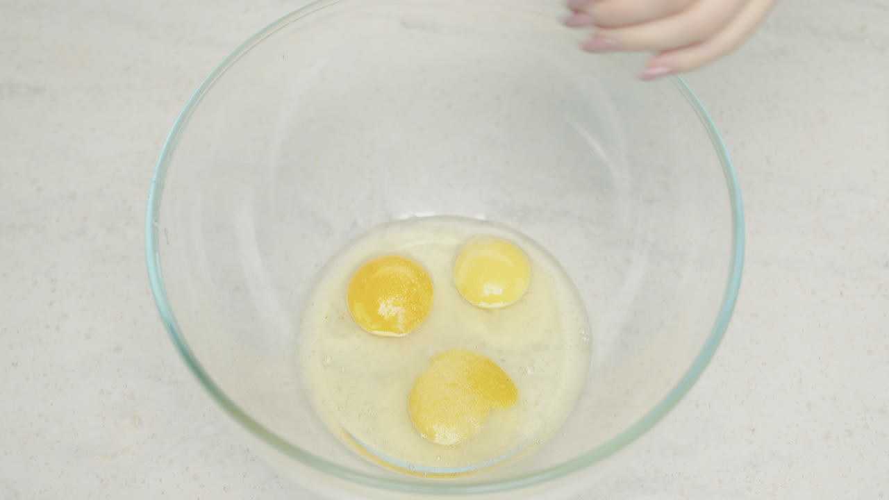 Whisking Raw Eggs in Glass Bowl