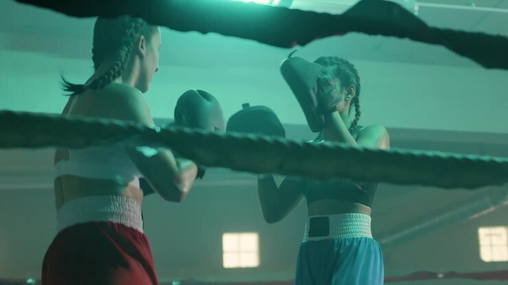 Due pugili donne caucasiche si allenano insieme in una palestra di boxe.