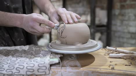 pottery artist shaping clay on a wheel