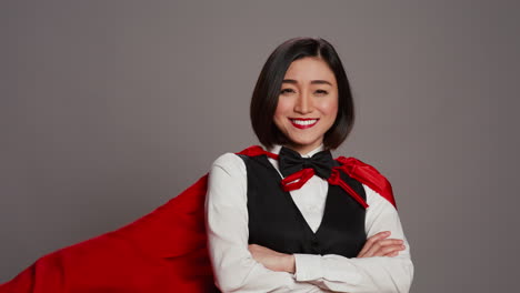 asian receptionist posing with red superhero cape on camera