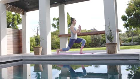 Mujer-Caucásica-Enfocada-Haciendo-Pose-De-Yoga-En-La-Alfombra-En-El-Jardín-En-Cámara-Lenta