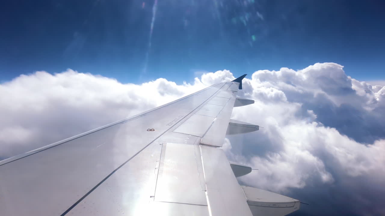 View from an airplane window of the aircraft wing in the clouds