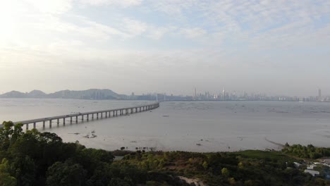 Puente-De-La-Bahía-De-Hong-Kong-Shenzhen-Con-Edificios-Tin-Shui-Wai-En-El-Horizonte-Y-Piscinas-De-Cultivo-De-Peces-Y-Ostras,-Vista-Aérea