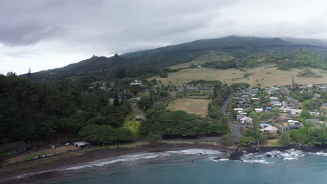 aerial wide reverse pullback shot of the small hawaiian village of hana town on the windward side of maui in hawai'i