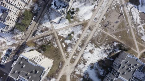 volando sobre el distrito de la era soviética con autos estacionados cerca de edificios a principios de la primavera nevada en vilnius