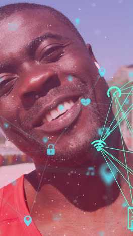 globos de iconos digitales girando contra el hombre afroamericano en forma agitando mirando a la cámara