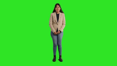 Full-Length-Studio-Portrait-Of-Female-Teacher-Talking-To-Class-Standing-Against-Green-Screen