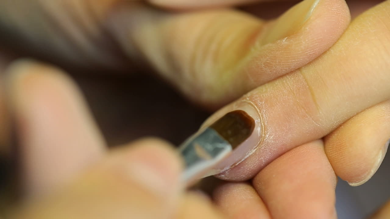 Manicurist treating client at beauty salon