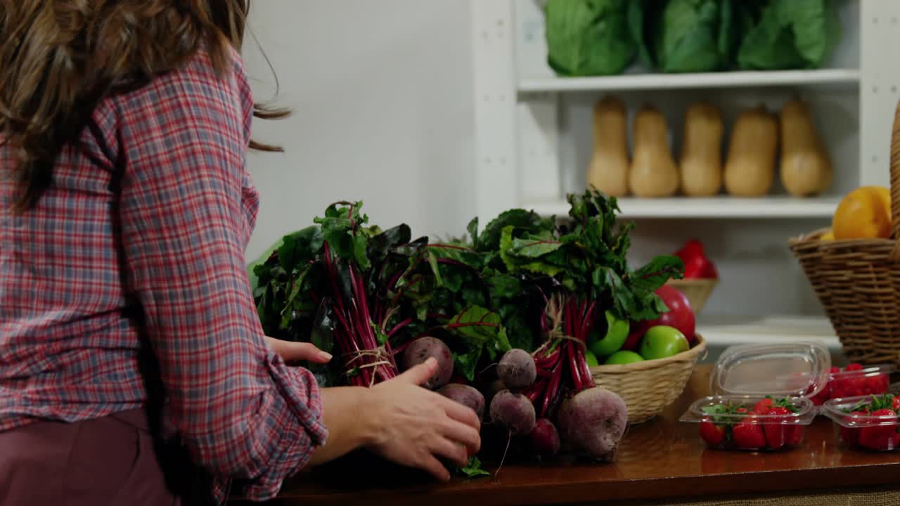 Vendor sorting beets on wood counter while frames panning HUD overlay marking produce for market