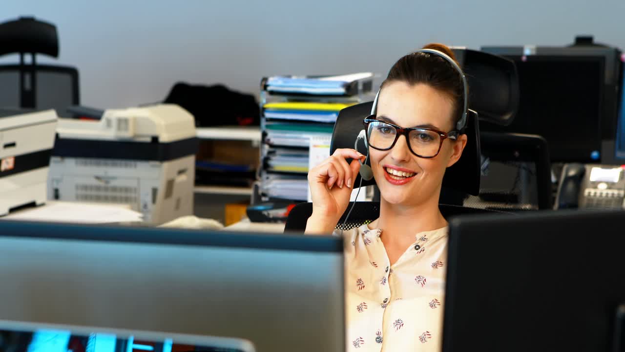 ejecutivo femenino hablando en auriculares en el escritorio