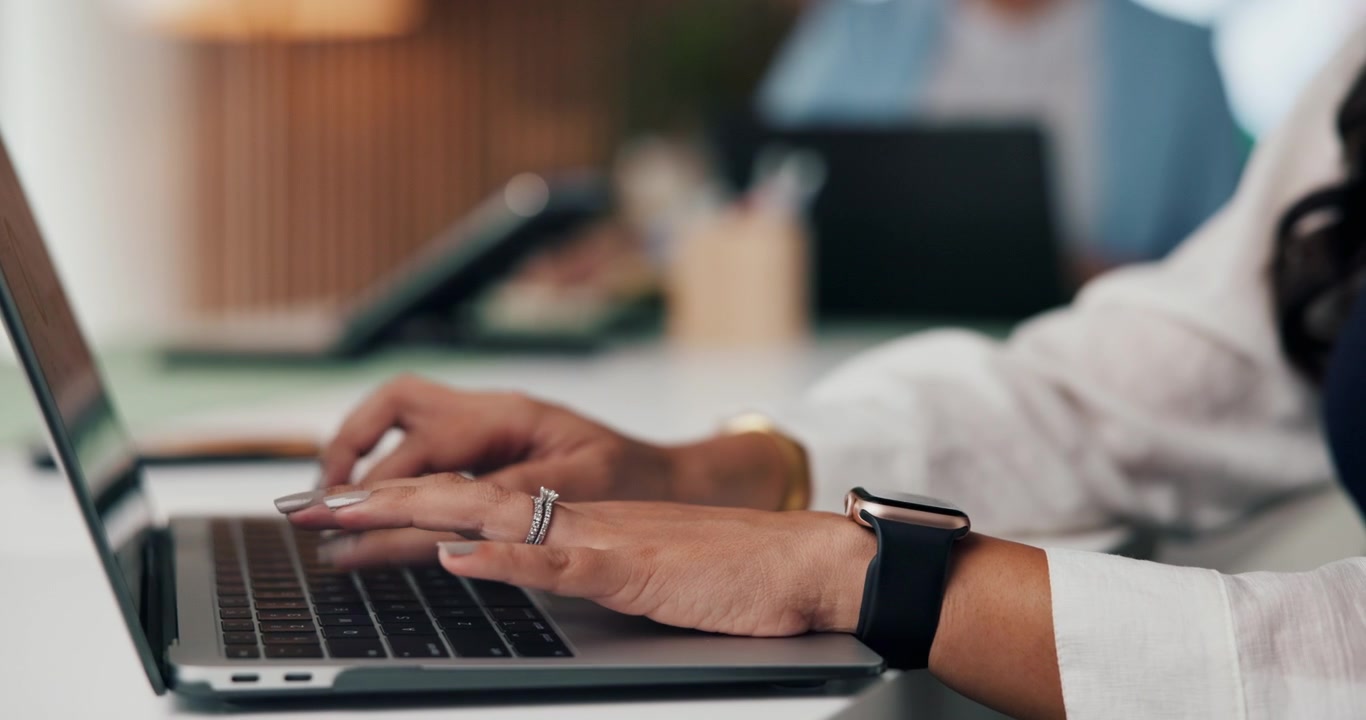 Close-up of Woman Typing on Laptop in Office