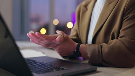 a woman experiencing wrist pain while using a laptop