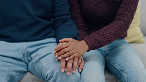 love, trust and couple on a sofa holding hands