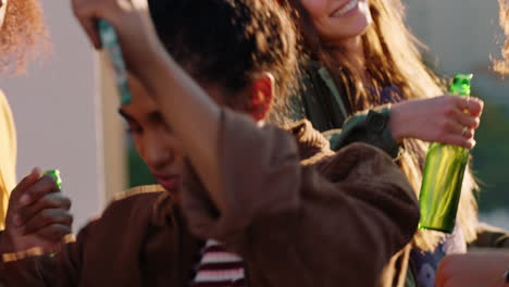 group of diverse friends hanging out dancing together mixed race woman enjoying rooftop party dance music at sunset drinking alcohol having fun on weekend gathering