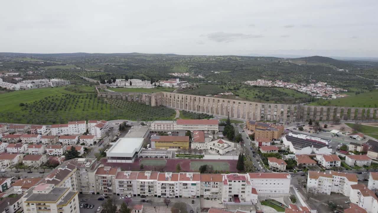 Aqueduto da Amoreira se estendendo sobre olivais e paisagem urbana em Elvas, Portugal - vista panorâmica aérea