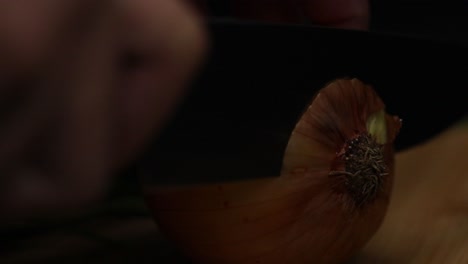 close up shot of hand as cutting the top of the onion, first cut in the peeling process