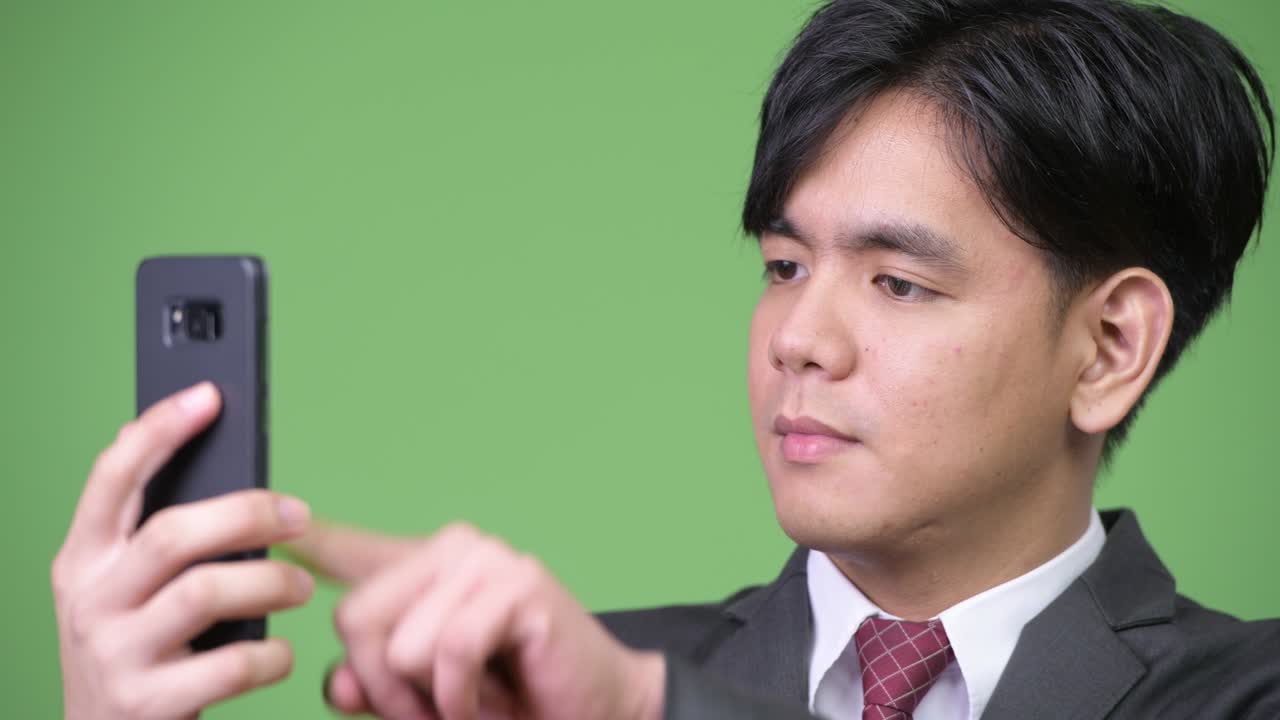 휴대전화를 사용하는 젊은 잘생긴 아시아 사업가