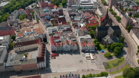 Aerial-tilt-down-footage-of-Neuer-Markt-square-with-colourful-gabled-houses-and-Saint-Mary-church.-Tram-tracks-leading-through-historic-city-centre