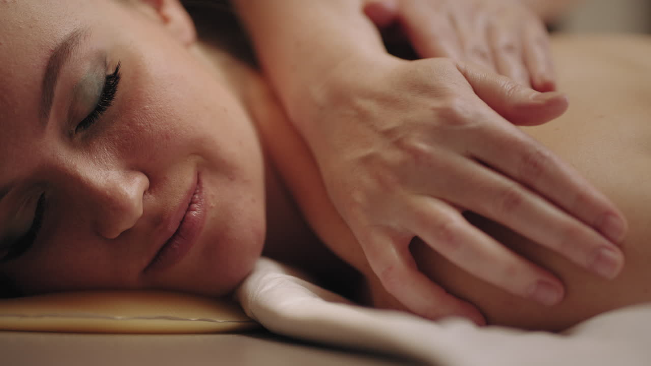 스파 살롱에서 전문적인 마사지 휴식 및 재활 치료 마사지 테이블에 행복한 여성 얼굴의 클로즈업