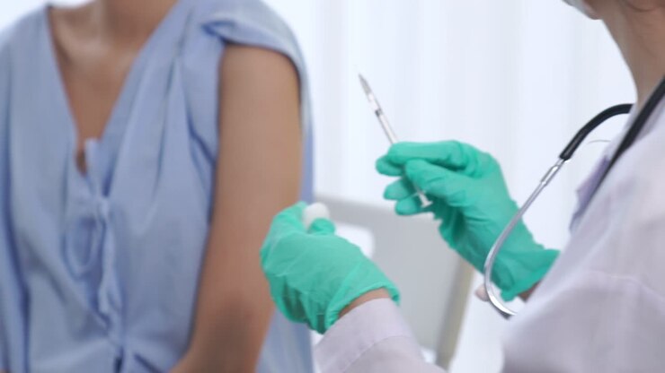 Young woman visits skillful doctor at hospital for vaccination