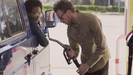 a young guy refuels his caravan for a road trip