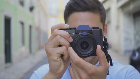 fotografo maschile allegro che scatta foto all'aperto.