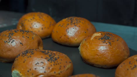 fresh hot barely oven hanburger buns bun sesame seed over stainless steel table at gourmet restaurant kitchen