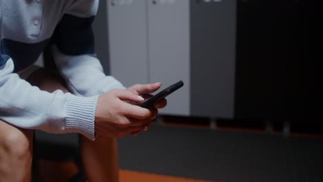 woman using phone in a locker room
