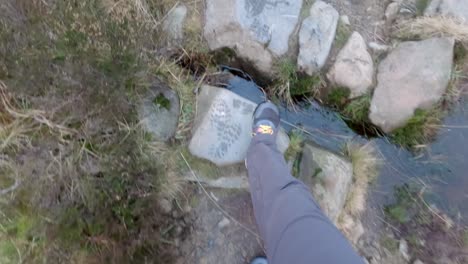 Hand-held-shot-of-a-man-walking-along-the-uneven-Gray-Mares-Trail-small-pathway