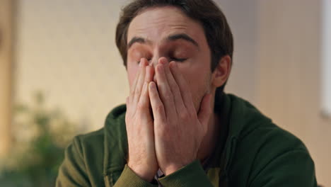 disappointed man covering face palm in office closeup. tired creator worried