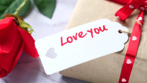 gift with "love you" tag and red rose