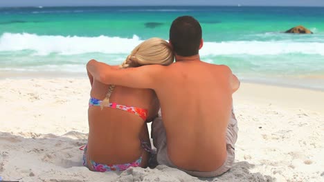 Sweet-couple-relaxing-and-embracing-in-front-of-the-sea