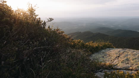 una toma de carro de paisaje en cámara lenta revela la vista de la puesta de sol sobre las montañas verdes y el lago champlain