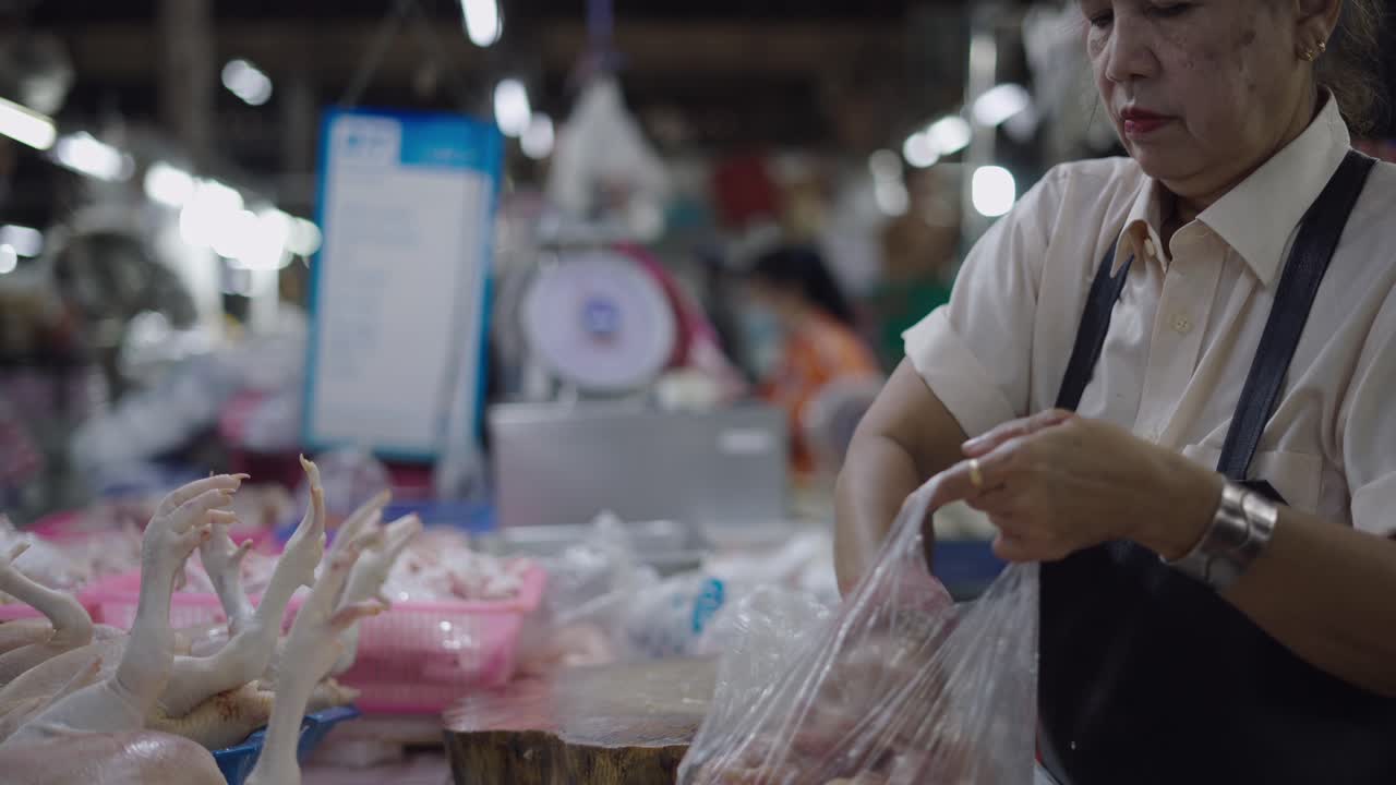 Woman preparing chicken parts at a market