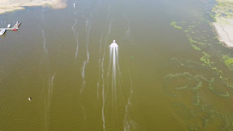 a boat glides gracefully across the water, leaving a trail of gentle ripples in its wake