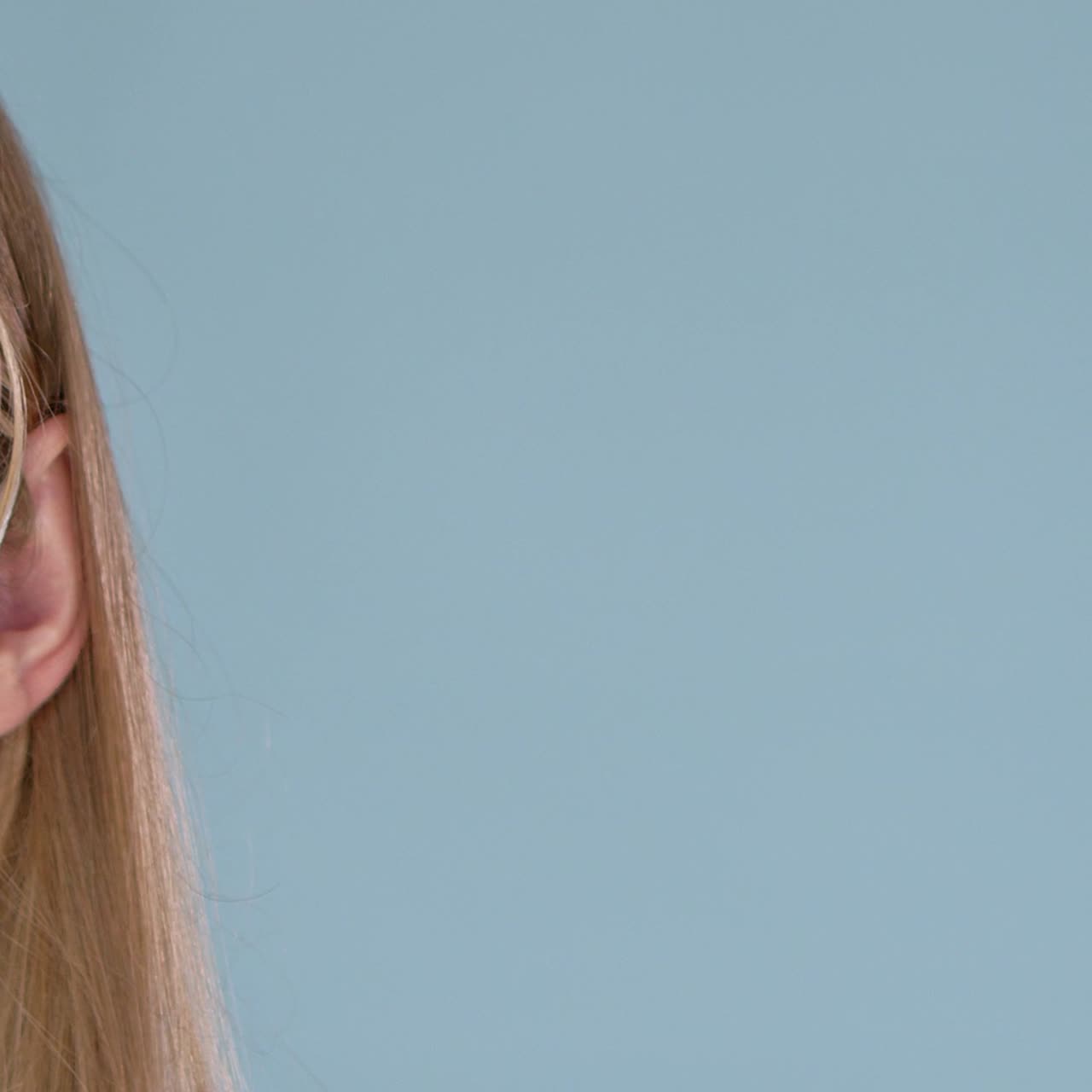 mujer joven posando con mascarilla médica mirando a la cámara con una sonrisa detrás