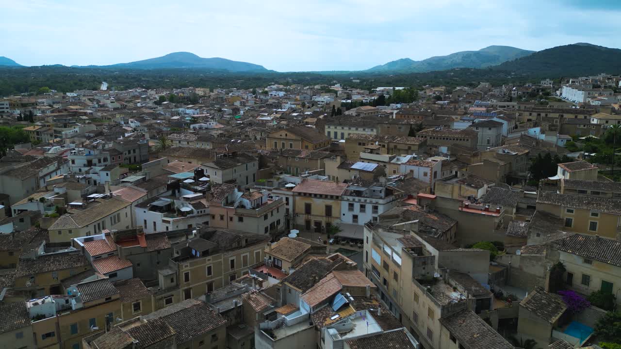Aerial of Arta town with dense stone houses and surrounding hills in Mallorca, panoramic establishing backdrop