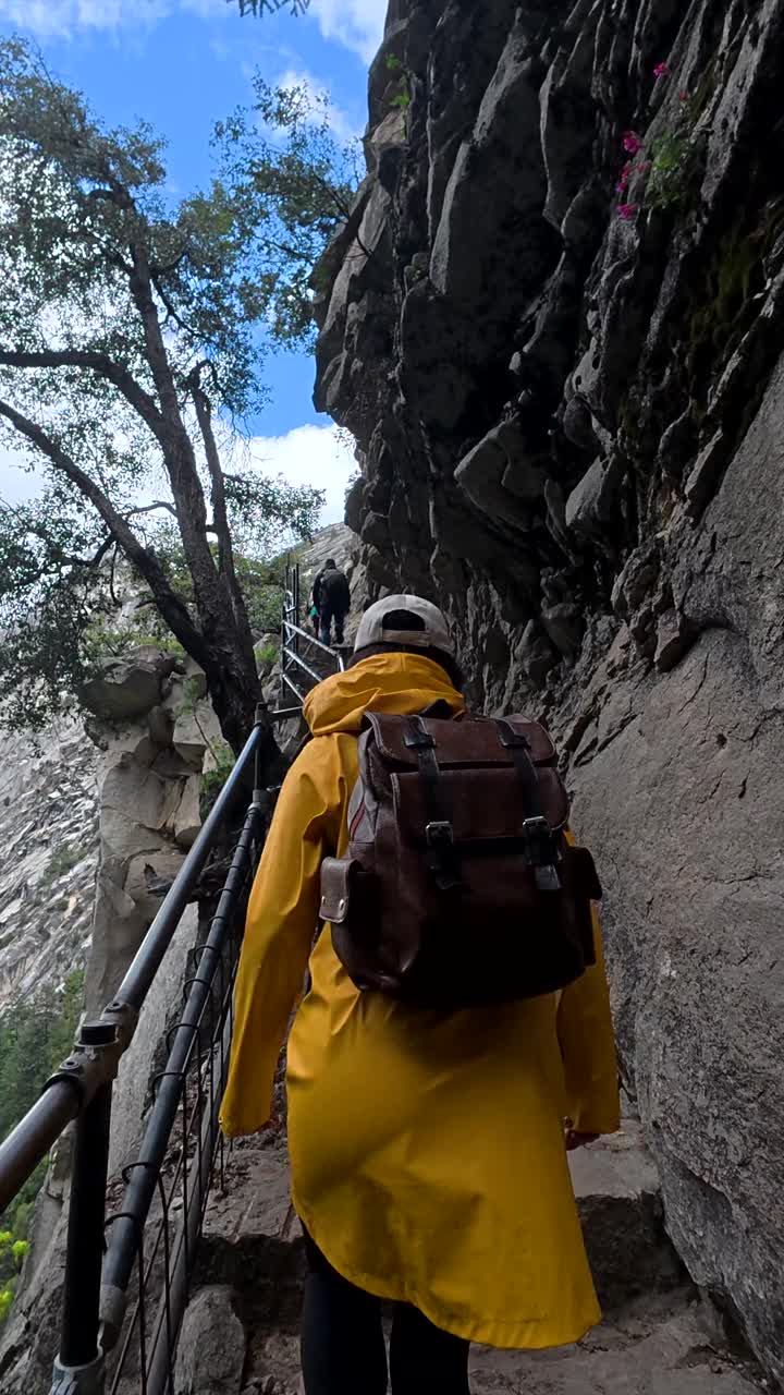 Donna che sale gradini rocciosi in montagna