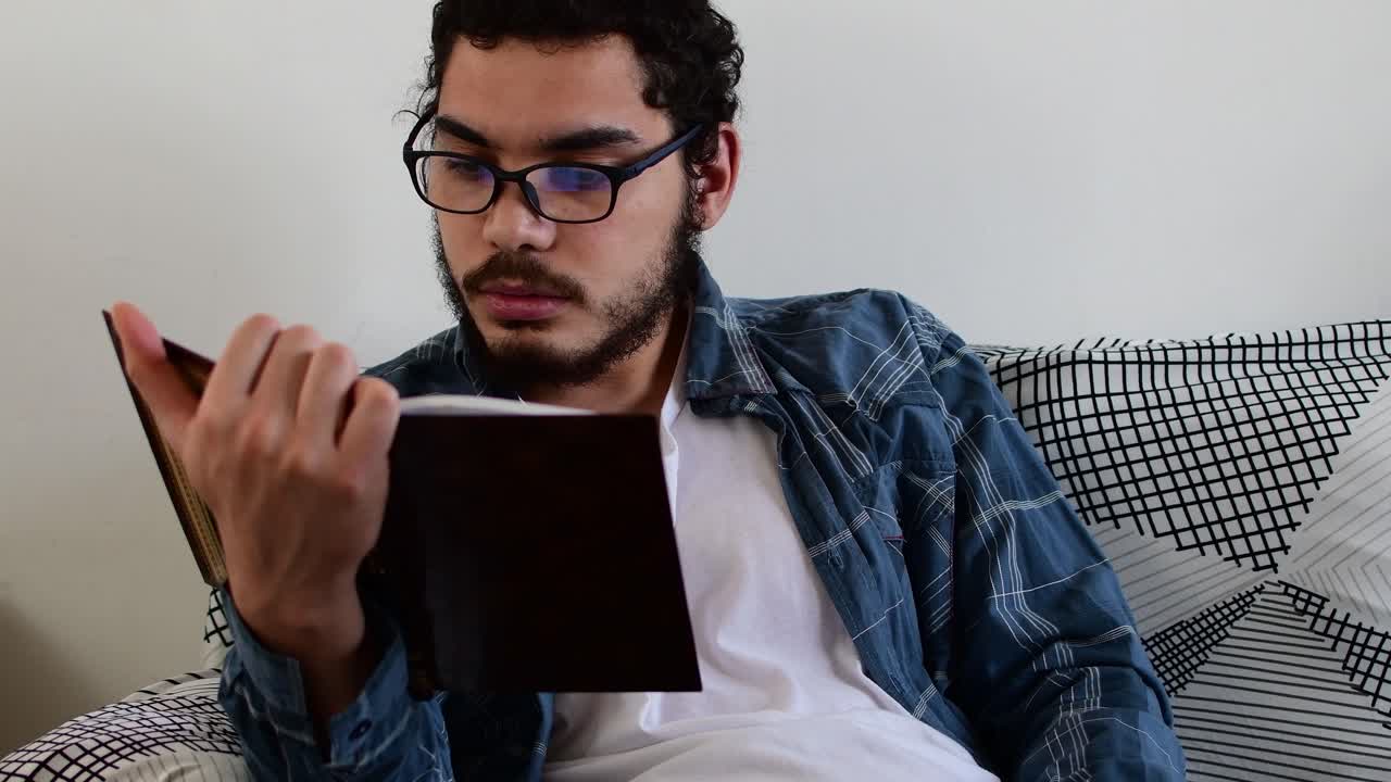 hombre leyendo un libro en un sofá