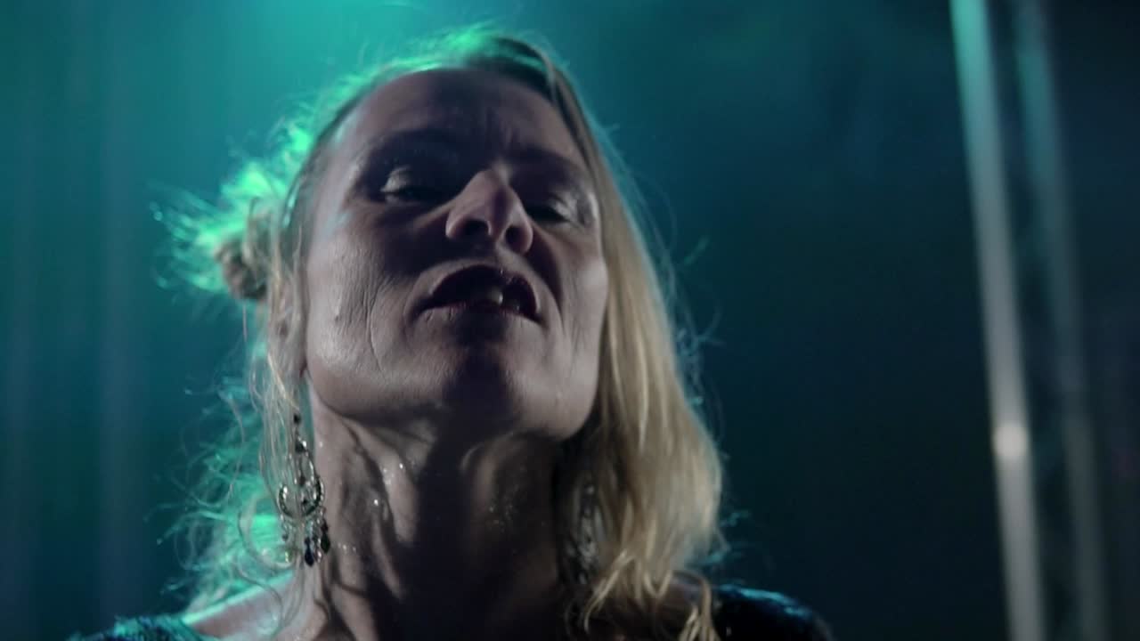 cámara lenta de un cantante rubio actuando en el escenario y sorprendiendo a la multitud con su canto en un concierto