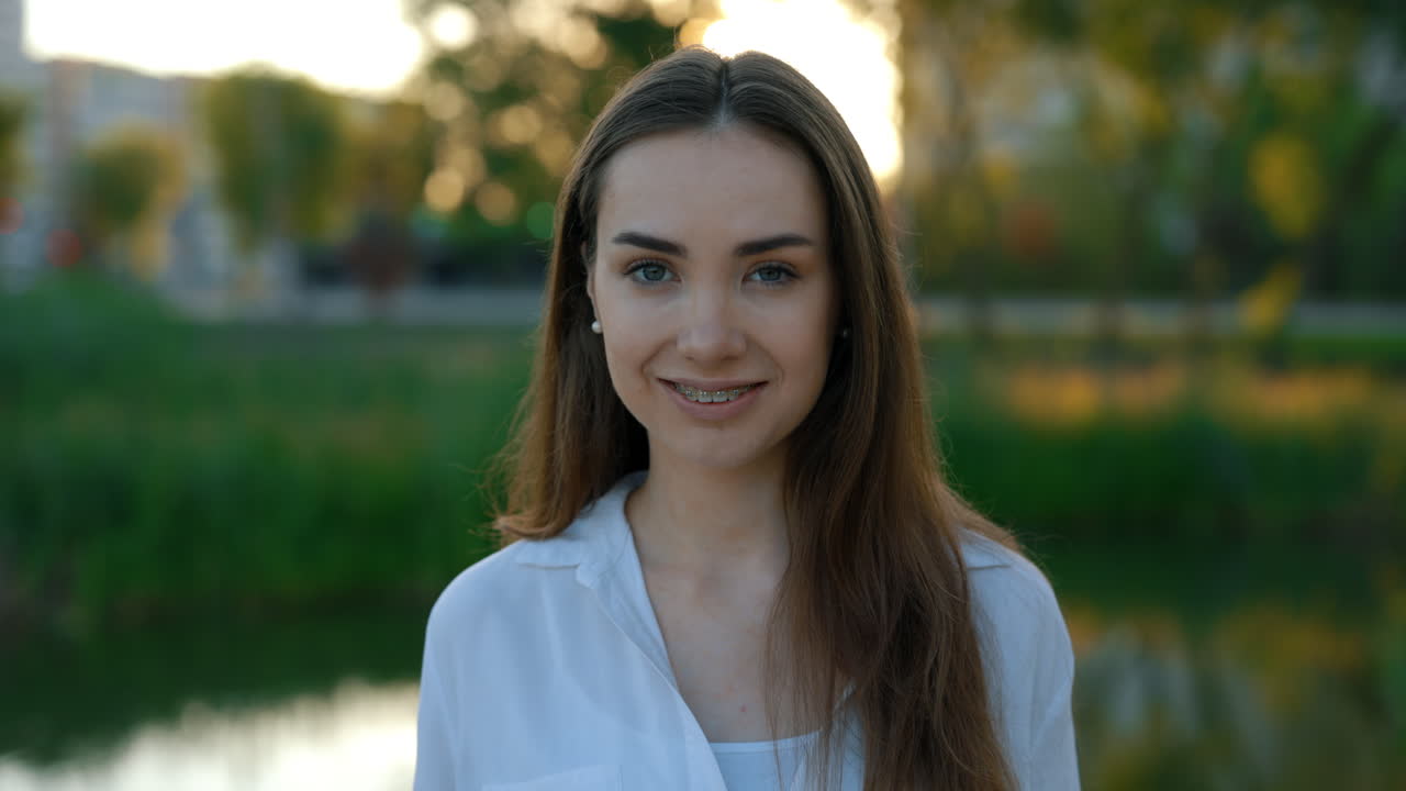 una mujer joven sonriendo en un parque.