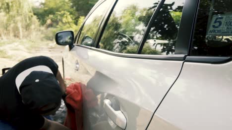 Close-up-of-a-male-wiping---drying-a-white-car