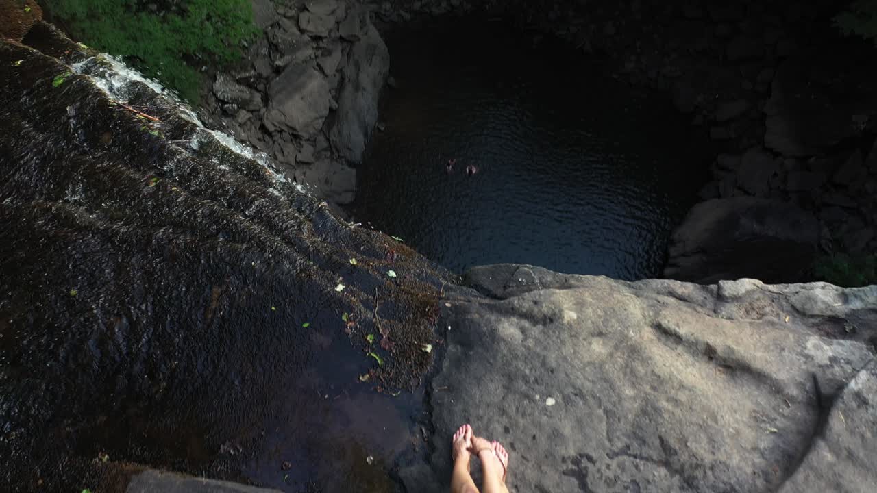 vista aérea de la mujer caminante sentada en la parte superior de las cataratas de ozono área natural de tennessee, ee.uu.
