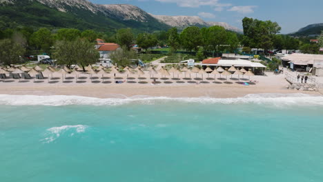 Tourists-Having-Vacation-On-Baska-Beach,-Resting-Under-Sunshade-During-Summer-In-Krk-Island,-Croatia