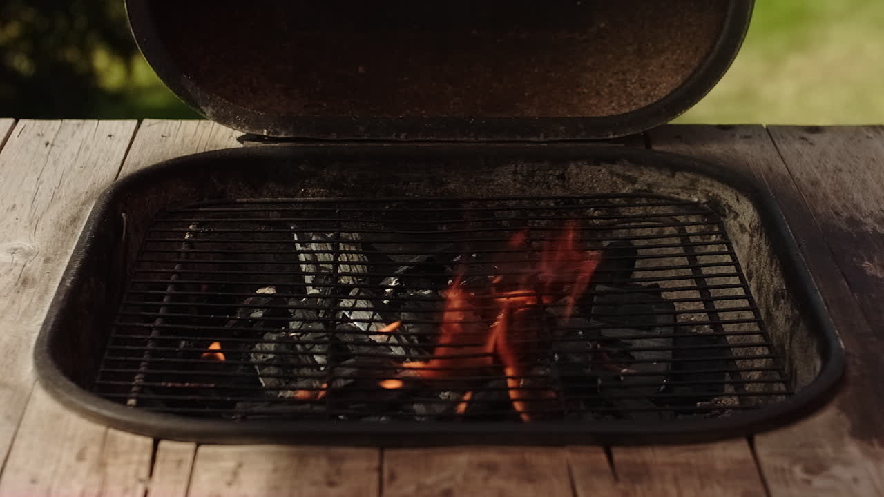 quemar carbón a fuego abierto en una barbacoa o parrilla en suecia en un cálido día de verano